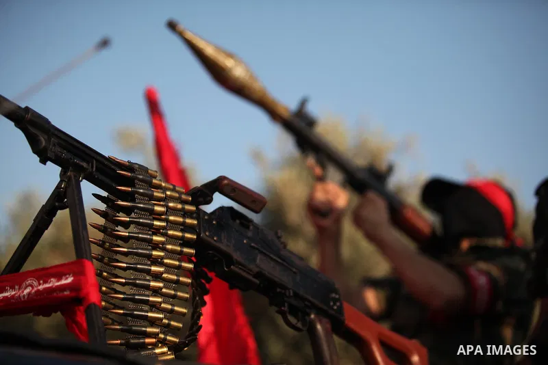 A masked Palestinian militant of the National Resistance Brigades, a group linked to the Democratic Front for the Liberation of Palestine holds his weapon during a military parade against the killing of a 18-month-old Pa...