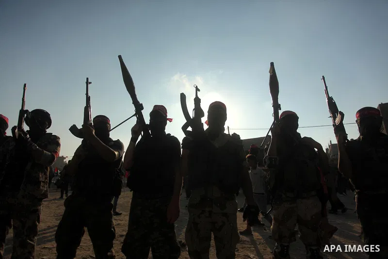Masked Palestinian militants of the National Resistance Brigades, a group linked to the Democratic Front for the Liberation of Palestine hold their weapons during a military parade against the killing of a 18-month-old P...