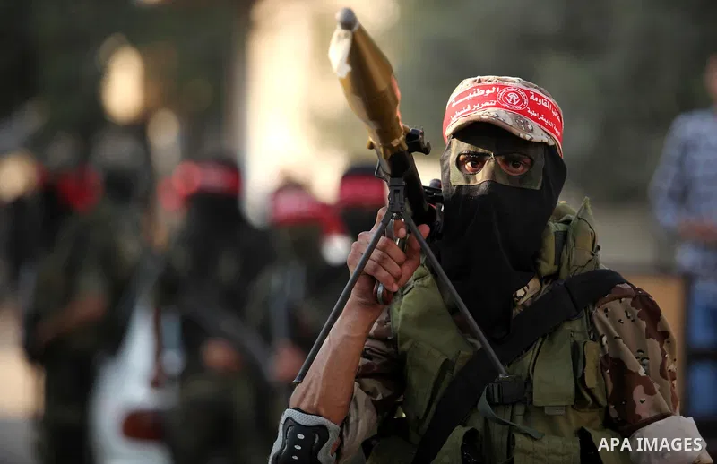 A masked Palestinian militant of the National Resistance Brigades, a group linked to the Democratic Front for the Liberation of Palestine holds his weapon during a military parade against the killing of a 18-month-old Pa...
