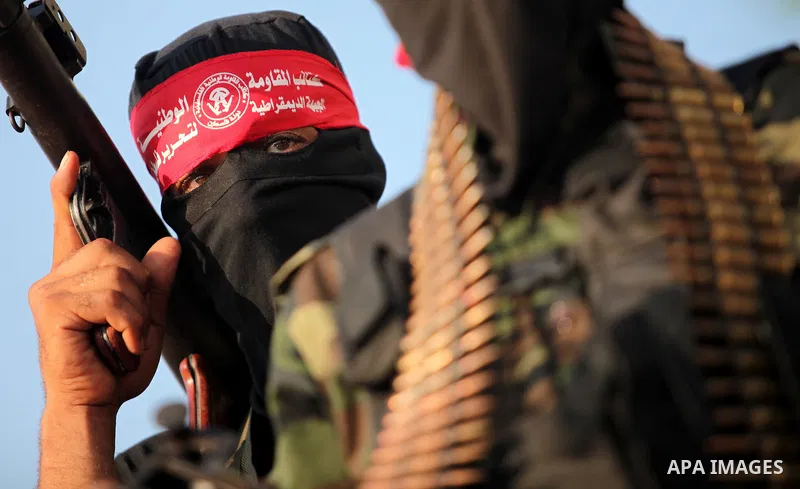 Masked Palestinian militants of the National Resistance Brigades, a group linked to the Democratic Front for the Liberation of Palestine hold their weapons during a military parade against the killing of a 18-month-old P...
