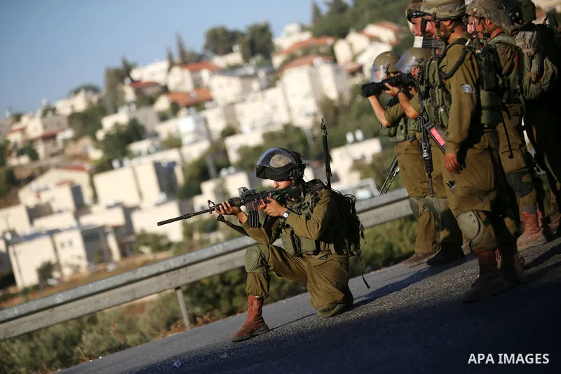 Israeli soldiers take position during clashes with Palestinian protesters nearby the Jalazoun refugee camp and the Jewish settlement of Beit El, north of Ramallah, after a demonstration in reaction to the death of a Pale...