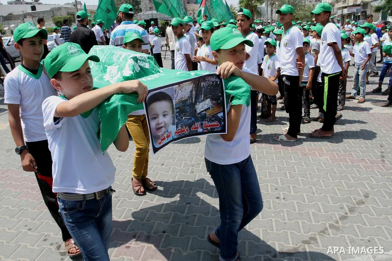 Palestinian children carry a funeral stretcher with a picture of 18-month-old Ali Saad Dawabsha, the toddler who was burned to death by suspected Jewish extremists, on August 1, 2015 in Khan Yunis in the southern Gaza St...