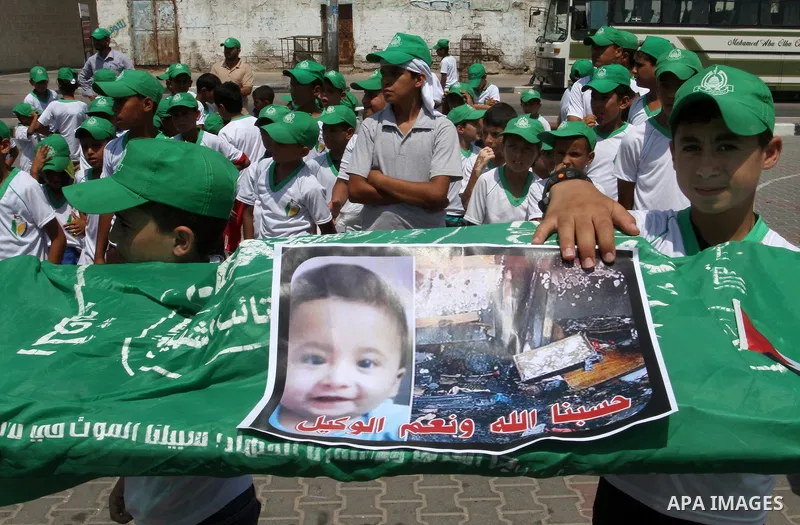 Palestinian children carry a funeral stretcher with a picture of 18-month-old Ali Saad Dawabsha, the toddler who was burned to death by suspected Jewish extremists, on August 1, 2015 in Khan Yunis in the southern Gaza St...