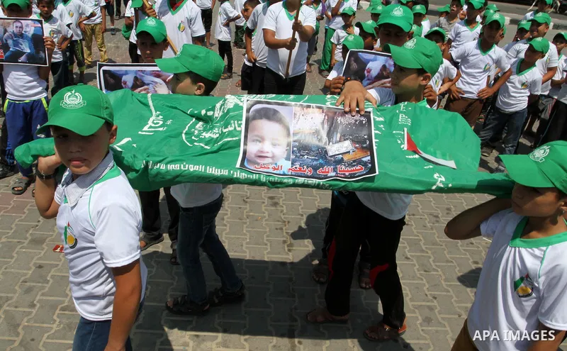 Palestinian children carry a funeral stretcher with a picture of 18-month-old Ali Saad Dawabsha, the toddler who was burned to death by suspected Jewish extremists, on August 1, 2015 in Khan Yunis in the southern Gaza St...