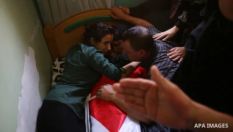 Mourners gather around the body of Palestinian youth Laith al-Khaldi during his funeral near the West Bank city of Ramallah August 1, 2015. Al-Khaldi died on Saturday at a West Bank hospital following a clash with Israel...