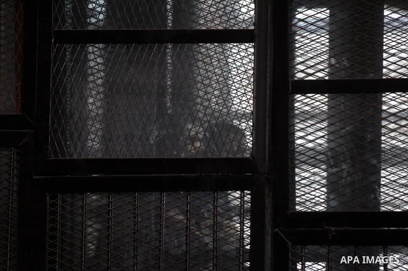 Egyptian radical Islamist Mohammed al-Zawahiri, the brother of Al-Qaeda chief Ayman al-Zawahiri, sits in the defendants cage during his trial with 68 other defendants, at a court in Cairo on August 01, 2015. Photo by Amr...