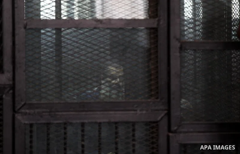 Egyptian radical Islamist Mohammed al-Zawahiri, the brother of Al-Qaeda chief Ayman al-Zawahiri, sits in the defendants cage during his trial with 68 other defendants, at a court in Cairo on August 01, 2015. Photo by Amr...