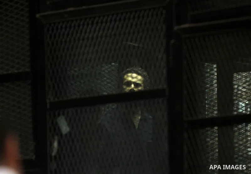 Egyptian radical Islamist Mohammed al-Zawahiri, the brother of Al-Qaeda chief Ayman al-Zawahiri, sits in the defendants cage during his trial with 68 other defendants, at a court in Cairo on August 01, 2015. Photo by Amr...