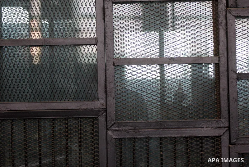 Egyptian radical Islamist Mohammed al-Zawahiri, the brother of Al-Qaeda chief Ayman al-Zawahiri, sits in the defendants cage during his trial with 68 other defendants, at a court in Cairo on August 01, 2015. Photo by Amr...