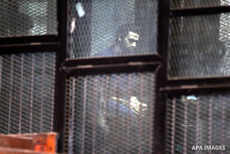 Egyptian radical Islamist Mohammed al-Zawahiri, the brother of Al-Qaeda chief Ayman al-Zawahiri, sits in the defendants cage during his trial with 68 other defendants, at a court in Cairo on August 01, 2015. Photo by Amr...