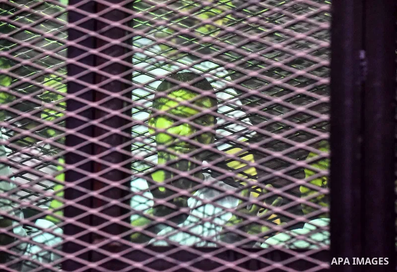 Egyptians defendants in Boulaq riots case, stand behind bars during their trial at a court in Cairo on August 01, 2015. Cairo Criminal Court delayed the trial of 379 Muslim Brotherhood (MB) members over charges of illega...