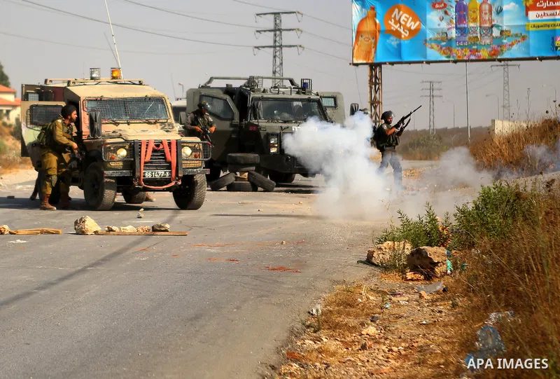 An Israeli soldier fires tear gas towards Palestinian protesters during clashes earby the Jalazoun refugee camp and the Jewish settlement of Beit El, north of Ramallah in reaction to the death of Palestinian youth Laith...