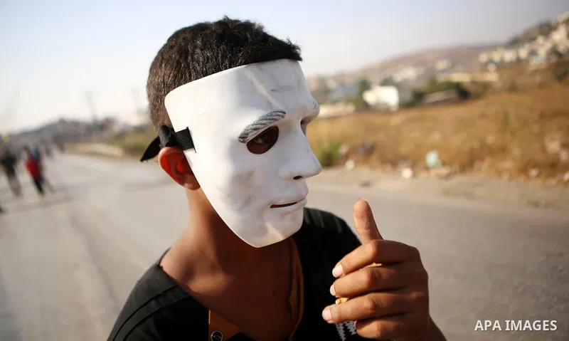 A Palestinian protester throws stones during clashes with Israeli security forces earby the Jalazoun refugee camp and the Jewish settlement of Beit El, north of Ramallah in reaction to the death of Palestinian youth Lait...