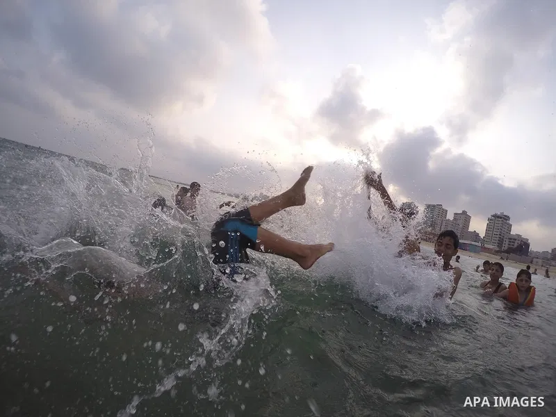 Palestinians enjoy the warm weather on a beach along the Mediterranean Sea in Gaza city, on August 2, 2015. Photo by Mohammed Asad