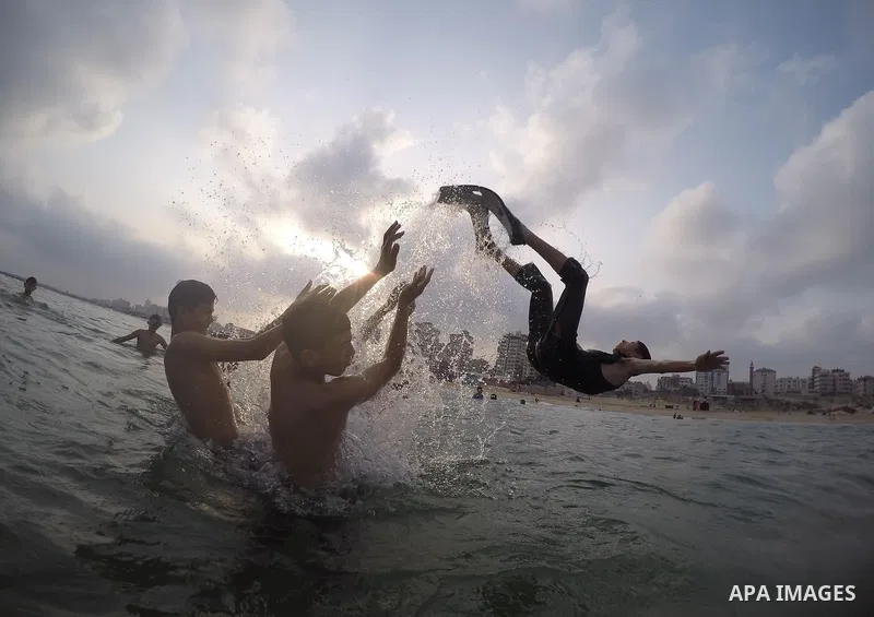 Palestinians enjoy the warm weather on a beach along the Mediterranean Sea in Gaza city, on August 2, 2015. Photo by Mohammed Asad