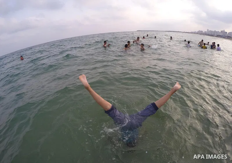 Palestinians enjoy the warm weather on a beach along the Mediterranean Sea in Gaza city, on August 2, 2015. Photo by Mohammed Asad