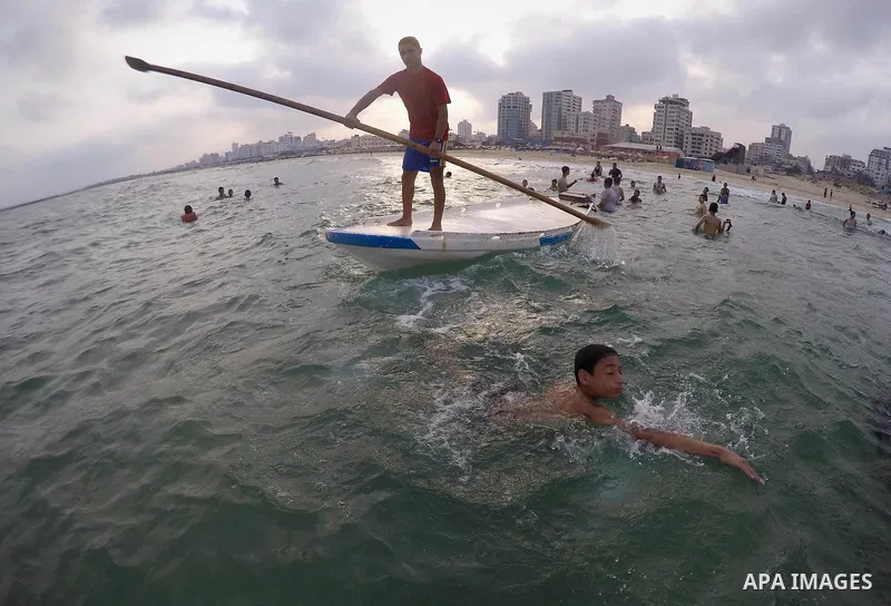 Palestinians enjoy the warm weather on a beach along the Mediterranean Sea in Gaza city, on August 2, 2015. Photo by Mohammed Asad