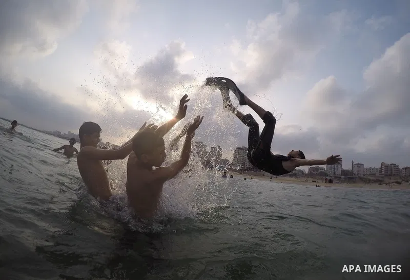 Palestinians enjoy the warm weather on a beach along the Mediterranean Sea in Gaza city, on August 2, 2015. Photo by Mohammed Asad
