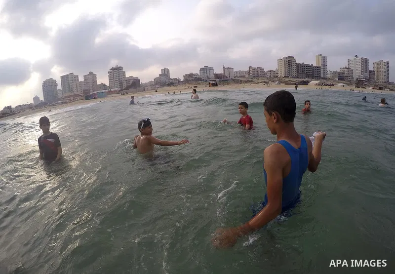 Palestinians enjoy the warm weather on a beach along the Mediterranean Sea in Gaza city, on August 2, 2015. Photo by Mohammed Asad
