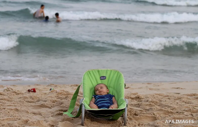 Palestinians enjoy the warm weather on a beach along the Mediterranean Sea in Gaza city, on August 2, 2015. Photo by Mohammed Asad