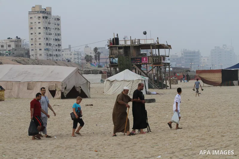 Palestinians enjoy the warm weather on a beach along the Mediterranean Sea in Gaza city, on August 2, 2015. Photo by Mohammed Asad