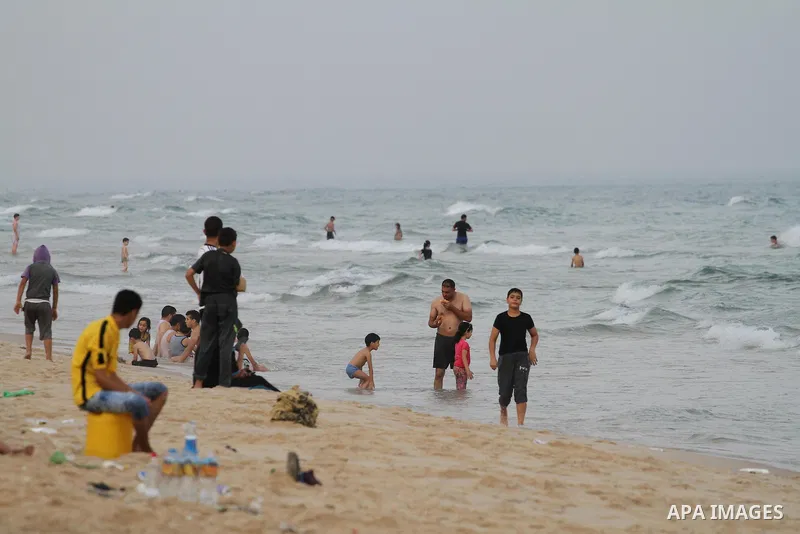 Palestinians enjoy the warm weather on a beach along the Mediterranean Sea in Gaza city, on August 2, 2015. Photo by Mohammed Asad