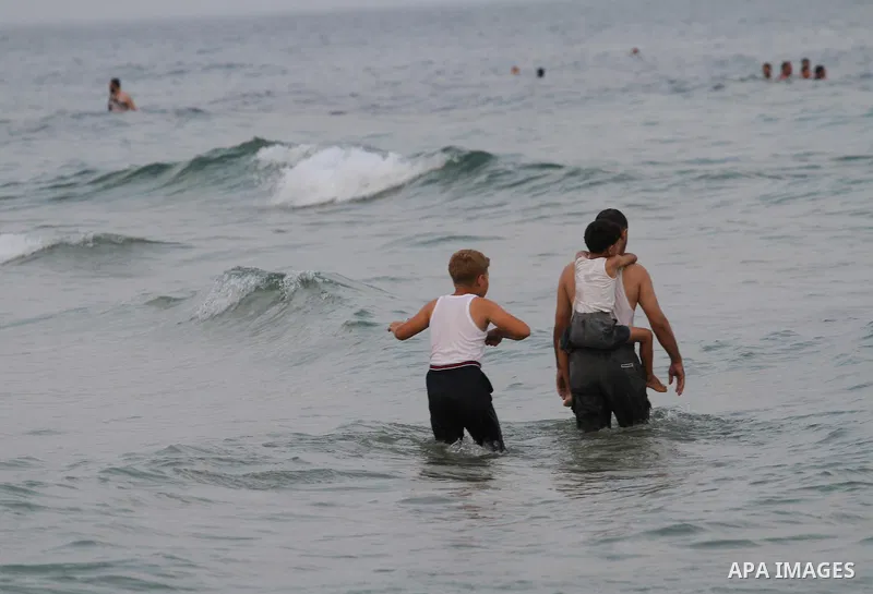 Palestinians enjoy the warm weather on a beach along the Mediterranean Sea in Gaza city, on August 2, 2015. Photo by Mohammed Asad