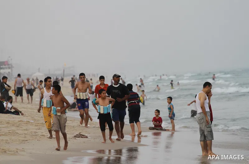 Palestinians enjoy the warm weather on a beach along the Mediterranean Sea in Gaza city, on August 2, 2015. Photo by Mohammed Asad