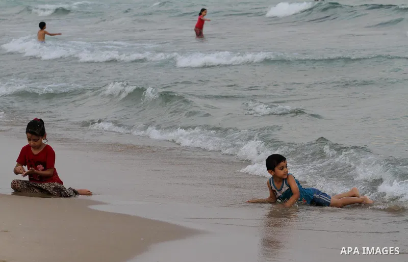Palestinians enjoy the warm weather on a beach along the Mediterranean Sea in Gaza city, on August 2, 2015. Photo by Mohammed Asad