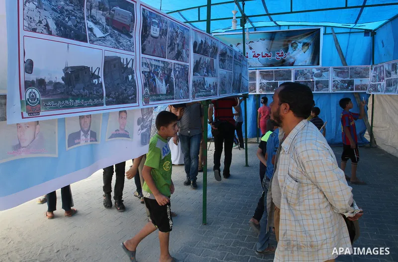 Palestinians attend a photo exhibition in Rafah in the southern Gaza strip, on August 2, 2015. Photo by Abed Rahim Khatib