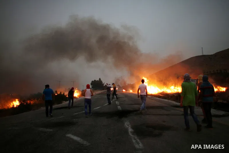 Palestinian protesters burn tires during clashes with Israeli security forces on a street leading to Duma village, on August 2, 2015, following a demonstration in reaction to the death of a Palestinian toddler burnt to d...