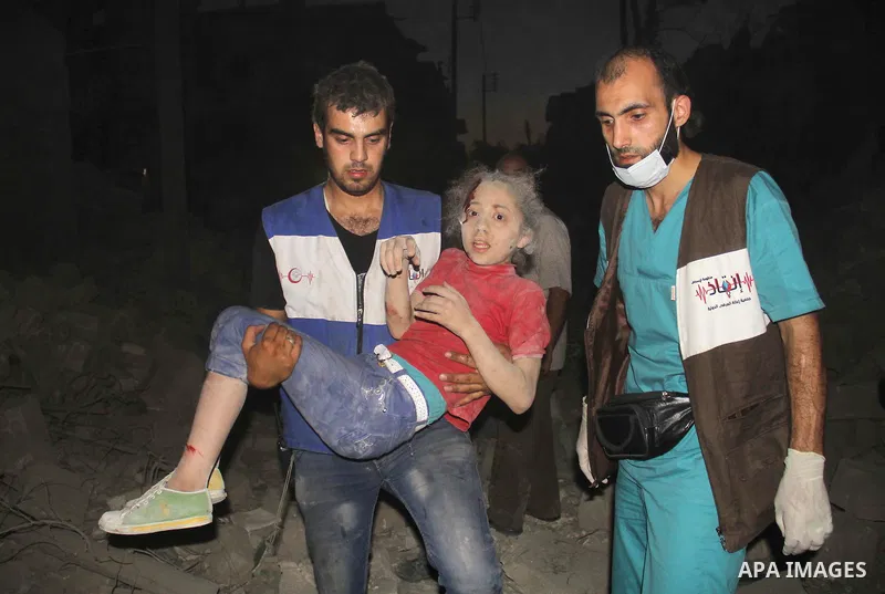 A member of Syrian civil defence carries an injured girl following a reported bomb barrel attack by forces of Syria's President Bashar al-Assad at the old city of Aleppo, on August 2, 2015. At least 1 civilian killed 8 o...
