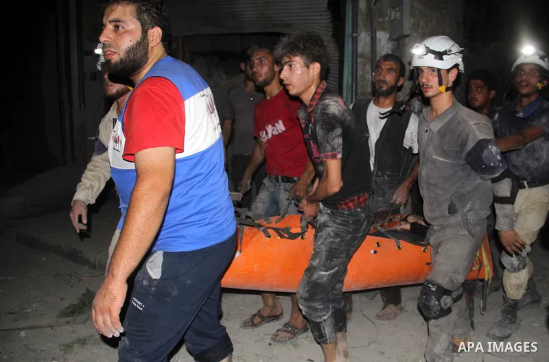 Syrian civil defence members carry an injured man following a reported bomb barrel attack by forces of Syria's President Bashar al-Assad at the old city of Aleppo, on August 2, 2015. At least 1 civilian killed 8 others w...