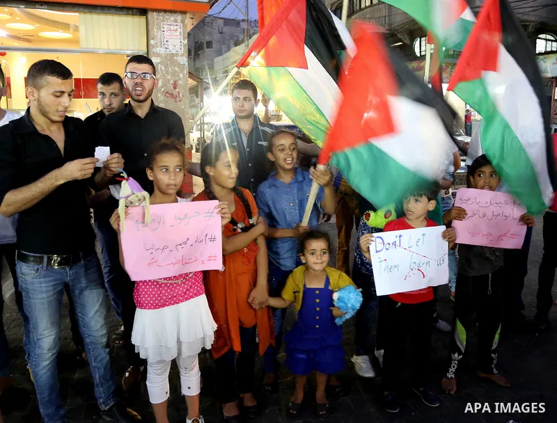 Palestinian children take part in a candle vigil in a protest against the killing of 18-month-old Palestinian Ali Saad Dawabsheh, the toddler who was burned to death by suspected Jewish extremists, in Jabalia in the nort...