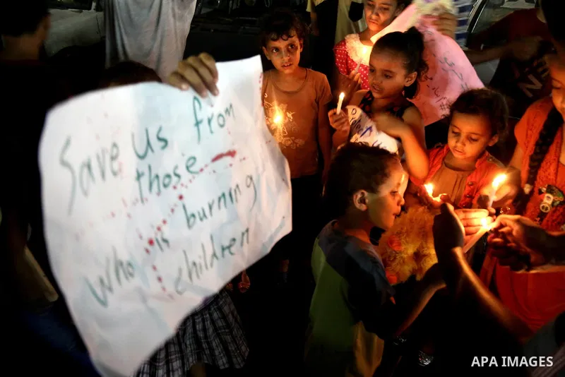 Palestinian children take part in a candle vigil in a protest against the killing of 18-month-old Palestinian Ali Saad Dawabsheh, the toddler who was burned to death by suspected Jewish extremists, in Jabalia in the nort...