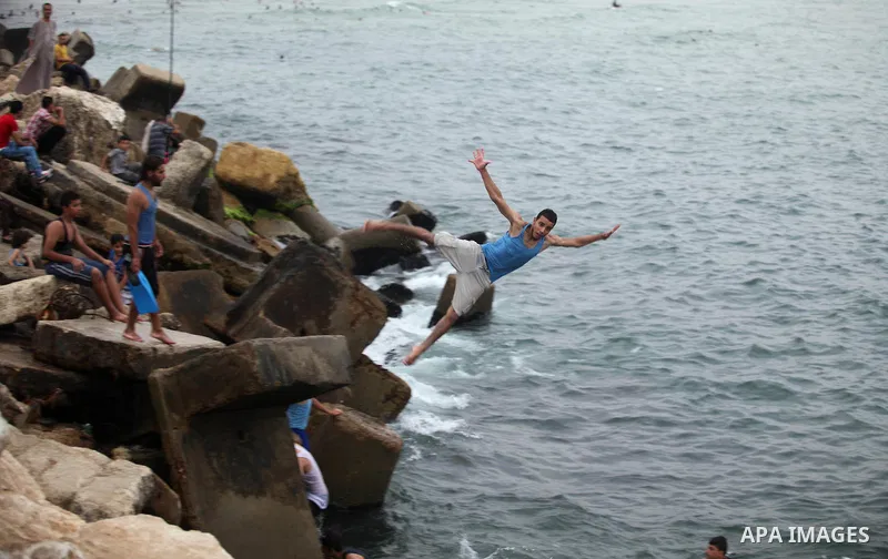 A Palestinian youth dives into the Mediterranean Sea on the coast of Gaza City on August 4, 2015. Across the Middle East, temperatures in the high 30’s Centigrade (upper 90’s Fahrenheit) and as high as 50 (122 Fahrenheit...