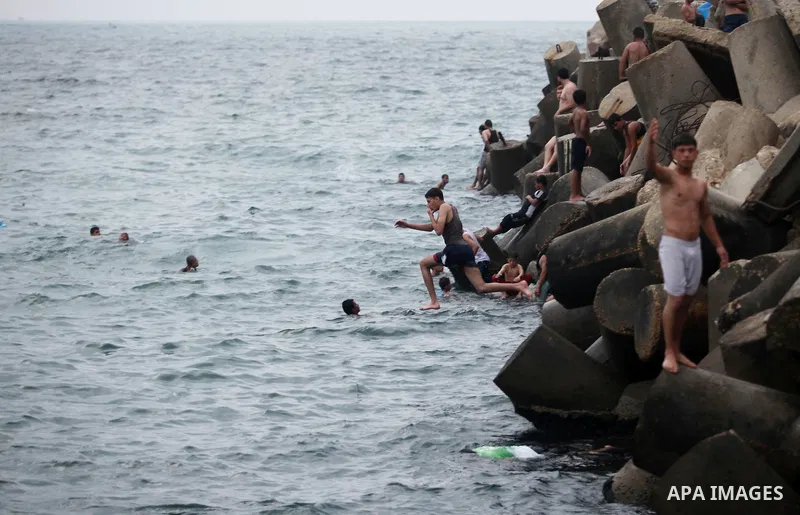 A Palestinian youth dives into the Mediterranean Sea on the coast of Gaza City on August 4, 2015. Across the Middle East, temperatures in the high 30’s Centigrade (upper 90’s Fahrenheit) and as high as 50 (122 Fahrenheit...