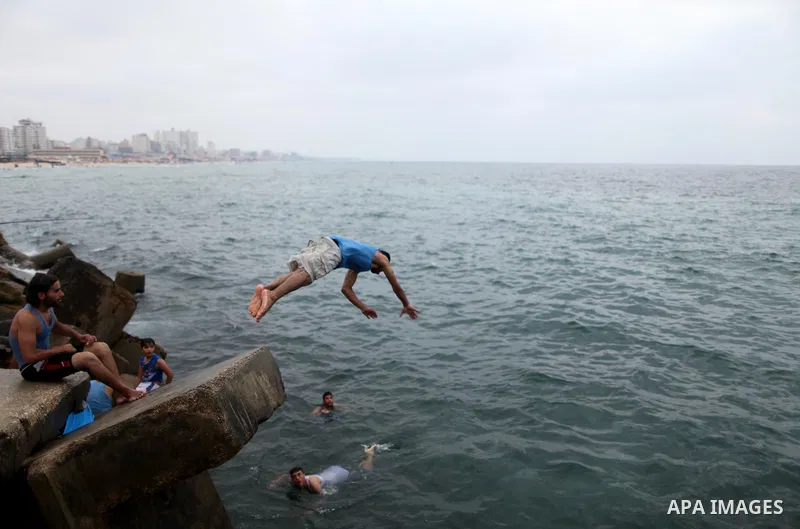 A Palestinian youth dives into the Mediterranean Sea on the coast of Gaza City on August 4, 2015. Across the Middle East, temperatures in the high 30’s Centigrade (upper 90’s Fahrenheit) and as high as 50 (122 Fahrenheit...