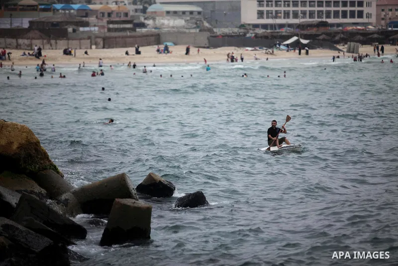 A Palestinian man rides a boat in the Mediterranean Sea on the coast of Gaza City on August 4, 2015. Across the Middle East, temperatures in the high 30’s Centigrade (upper 90’s Fahrenheit) and as high as 50 (122 Fahrenh...