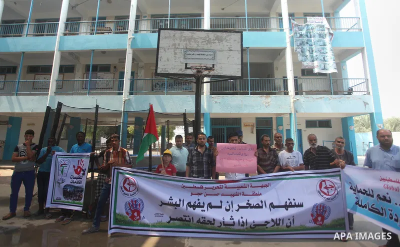 Palestinians hold banners during a protest against the reduction of educational programs given by United Nations Relief and Works Agency (UNRWA) in Dair Al Balah in the center of Gaza strip on August 5, 2015. The UNRWA s...