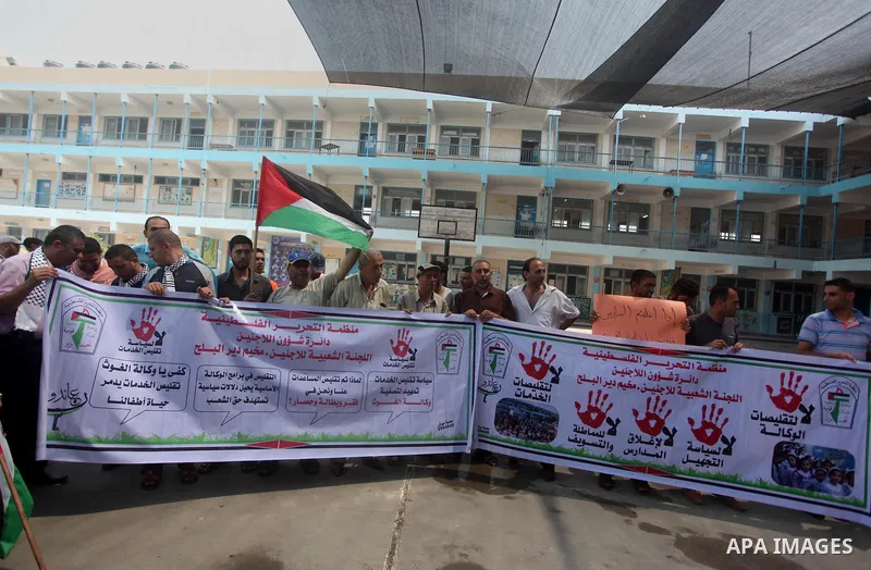 Palestinians hold banners during a protest against the reduction of educational programs given by United Nations Relief and Works Agency (UNRWA) in Dair Al Balah in the center of Gaza strip on August 5, 2015. The UNRWA s...
