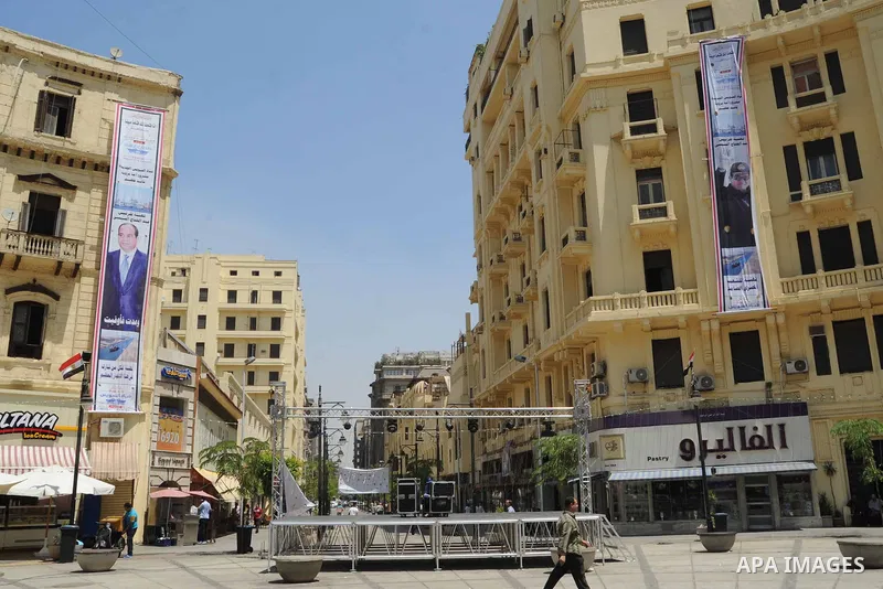 Egyptians walk past a posters of Egyptian President Abdel Fattah al-Sisi on a building, in cairo, on August 5, 2015. Egypt on Thursday, Aug. 6, will unveil a major extension of the Suez Canal, a mega-project that has eme...