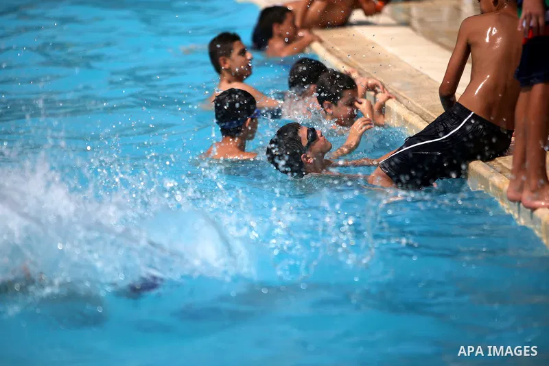 Palestinian youths enjoy swimming in a pool at a park in the West Bank city of Ramallah on August 5, 2015. Across the Middle East, temperatures in the high 30s Centigrade (upper 90s Fahrenheit) and as high as 50 (122 Fah...