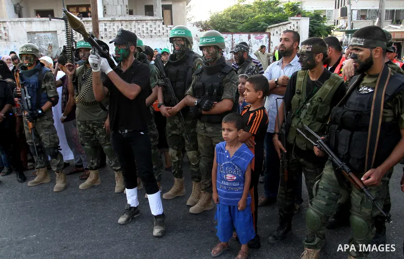 Members of Ezzedin al-Qassam Brigades, the armed wing of Hamas movement, take part in a graduation ceremony of a military-style camp organized by the Hamas movement in Khan Younis in the southern Gaza Strip, on August 5,...
