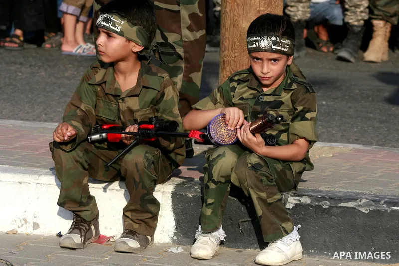 Palestinian children attend a graduation ceremony of a military-style camp organized by the Hamas movement in Khan Younis in the southern Gaza Strip, on August 5, 2015. Hamas's armed wing organized ''Liberation Youths Ca...