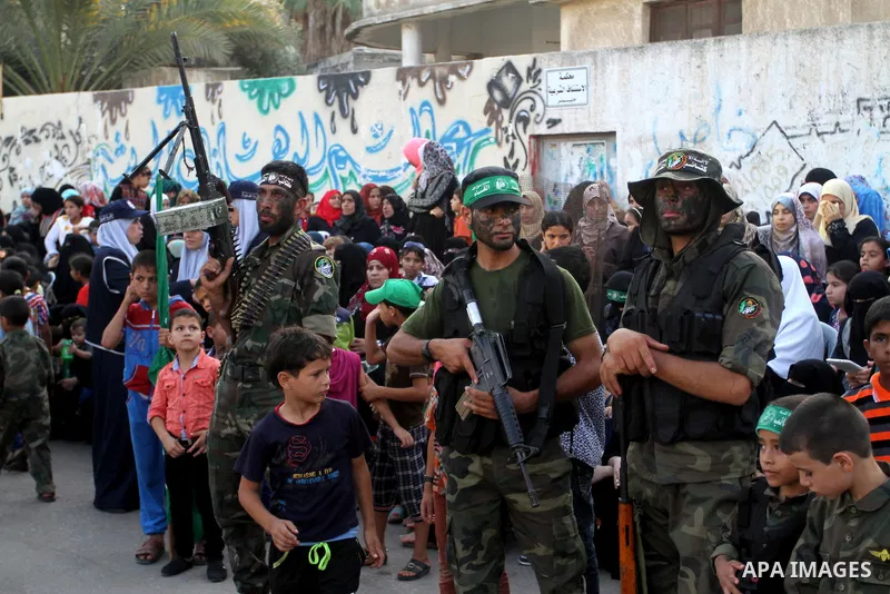 Members of Ezzedin al-Qassam Brigades, the armed wing of Hamas movement, take part in a graduation ceremony of a military-style camp organized by the Hamas movement in Khan Younis in the southern Gaza Strip, on August 5,...