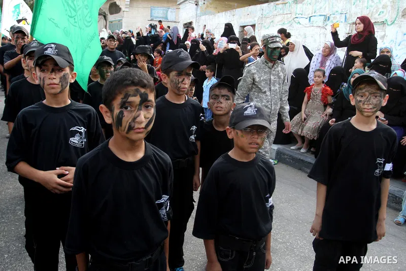 Palestinian youths take part in a graduation ceremony of a military-style camp organized by the Hamas movement in Khan Younis in the southern Gaza Strip, on August 5, 2015. Hamas's armed wing organized ''Liberation Youth...
