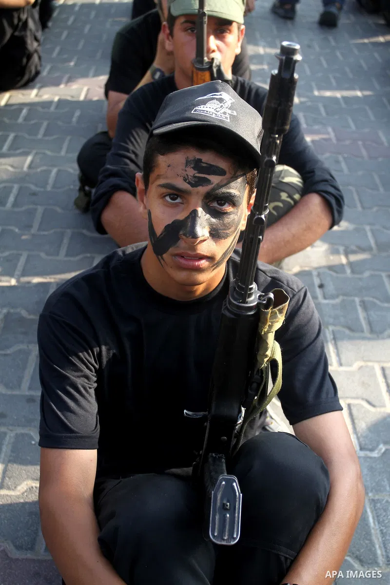 Palestinian youths take part in a graduation ceremony of a military-style camp organized by the Hamas movement in Khan Younis in the southern Gaza Strip, on August 5, 2015. Hamas's armed wing organized ''Liberation Youth...