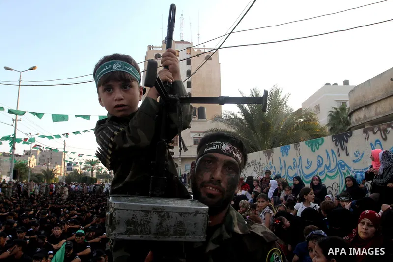 A Palestinian boy attends a graduation ceremony of a military-style camp organized by the Hamas movement in Khan Younis in the southern Gaza Strip, on August 5, 2015. Hamas's armed wing organized ''Liberation Youths Camp...