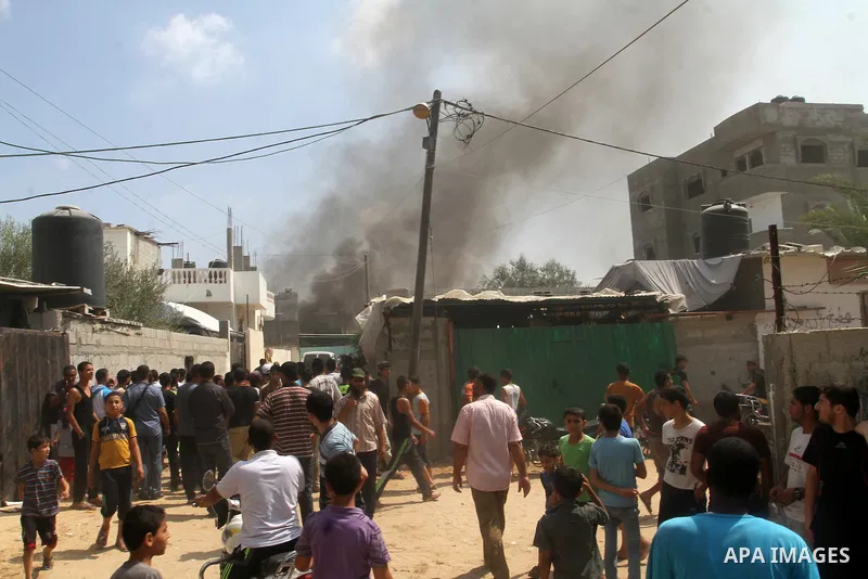 Palestinians gather at the site of an explosion that ripped through a house in the Al-Shabura refugee camp near the southern Gaza Strip town of Rafah on August 6, 2015. The blast killed at least two people and wounded 20...